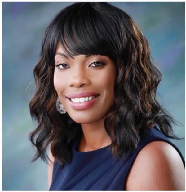 Cynthia Laine professional headshot image - she has long wavy black hair, and is wearing a black dress and smiling.